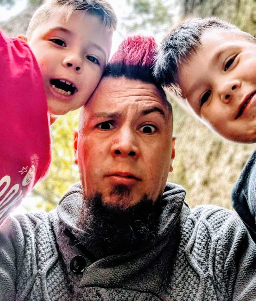 Dad with a red mohawk takes a goofy selfie with his two sons