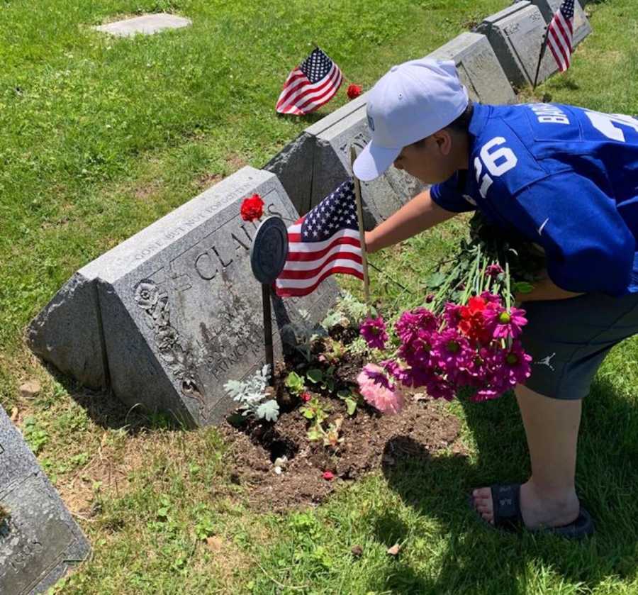 young boy putting flowers on Veterans graves