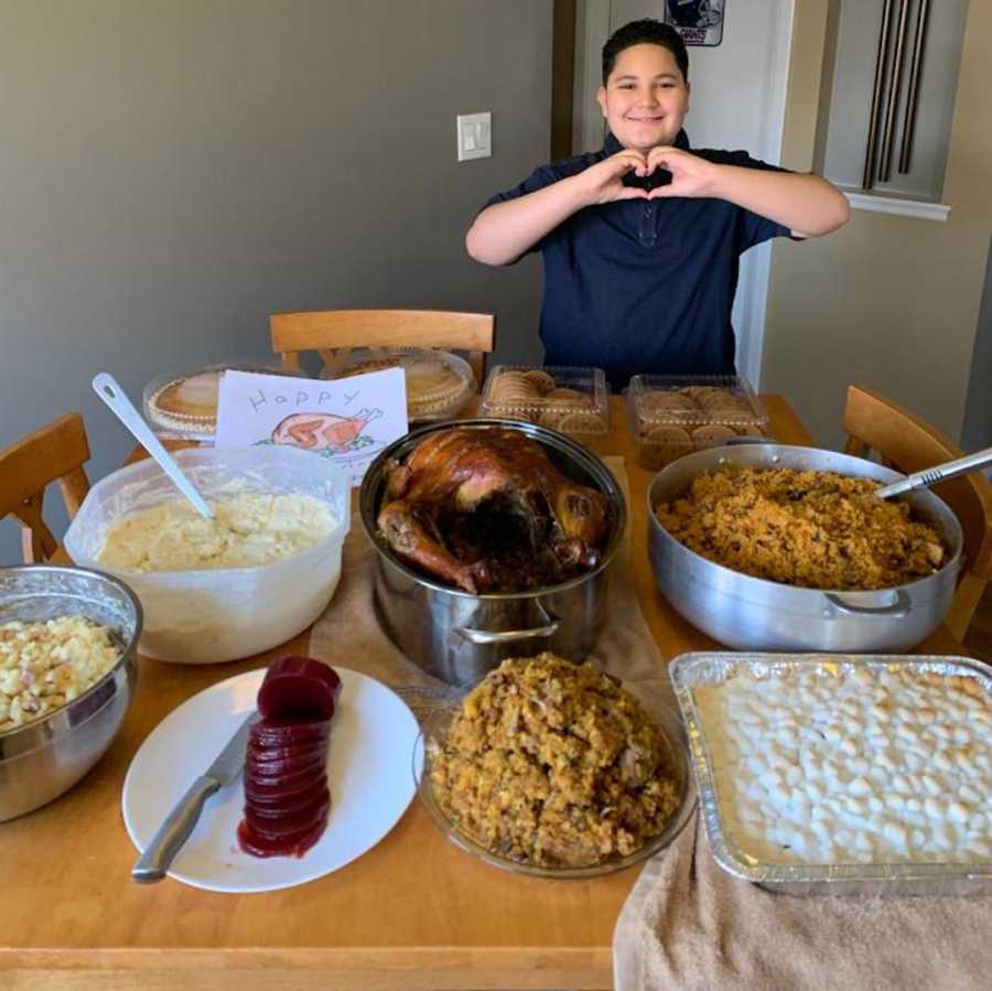 young boy with Thanksgiving dinner on table