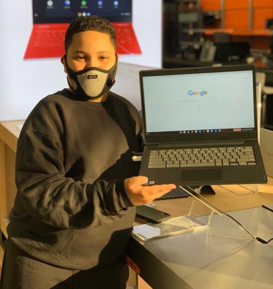 young boy holding laptop