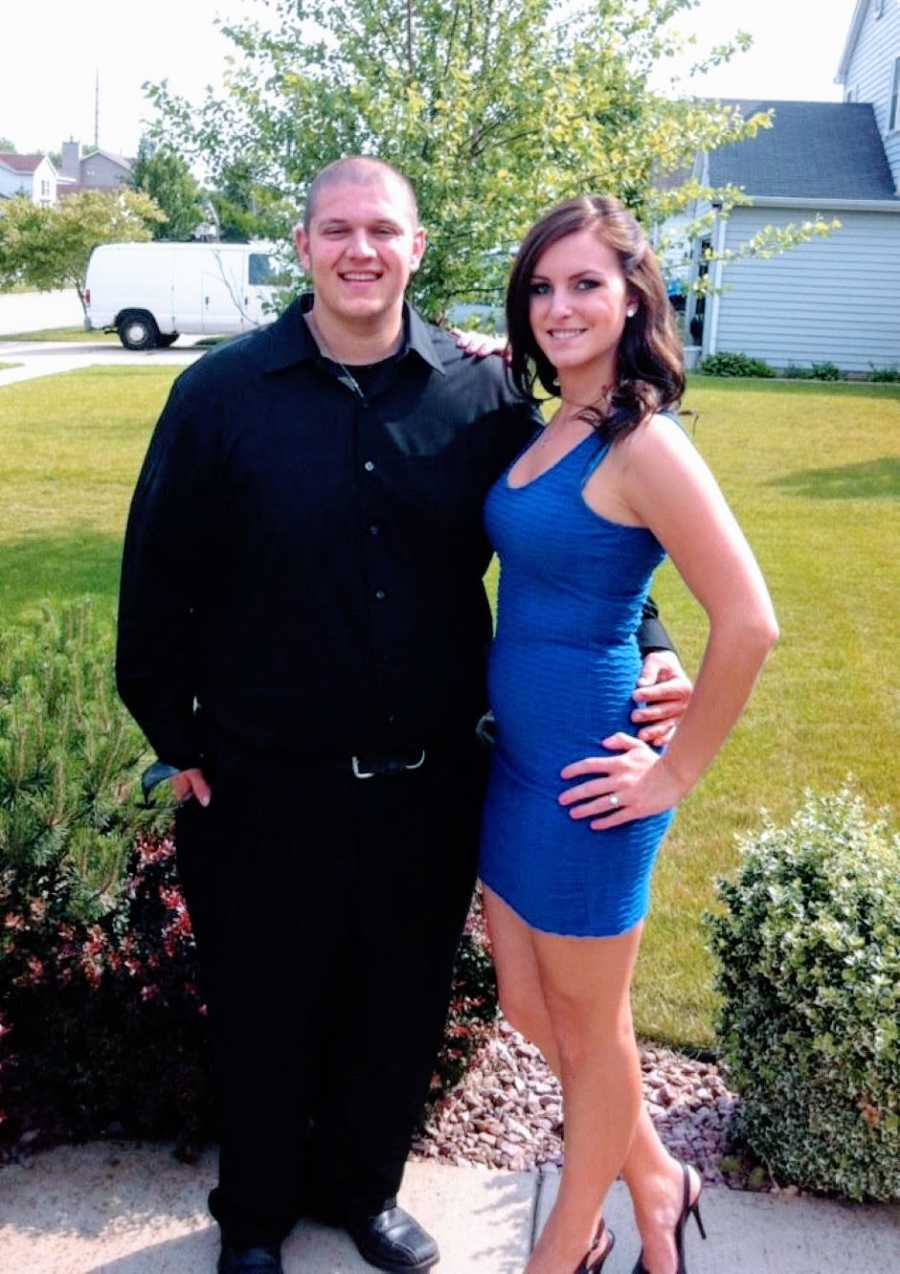 Young couple pose in a black suit and blue dress before going to a formal event