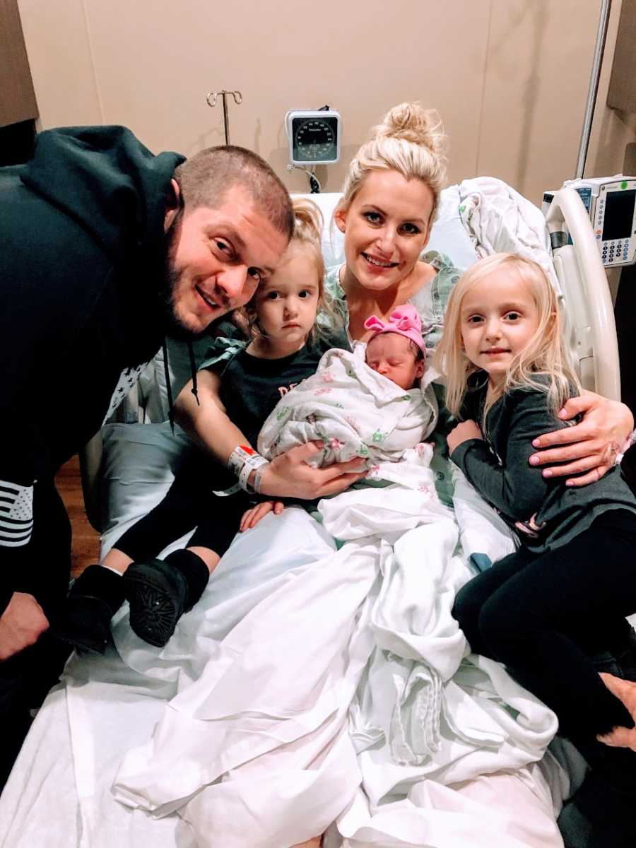 Mom takes photo with newborn daughter and rest of her family in the hospital after birth