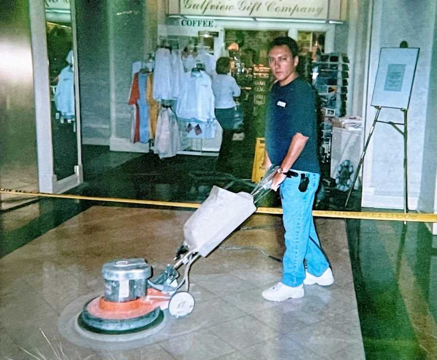 A man uses a machine to buff the floor at his work