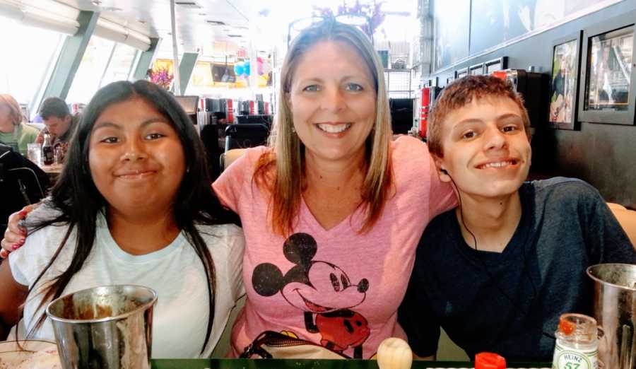 Mom of two adopted children takes a photo with them in Disney