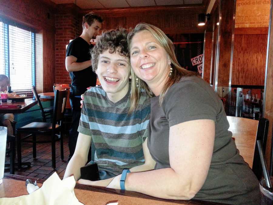 Mom takes a photo with her adopted autistic son in a restaurant