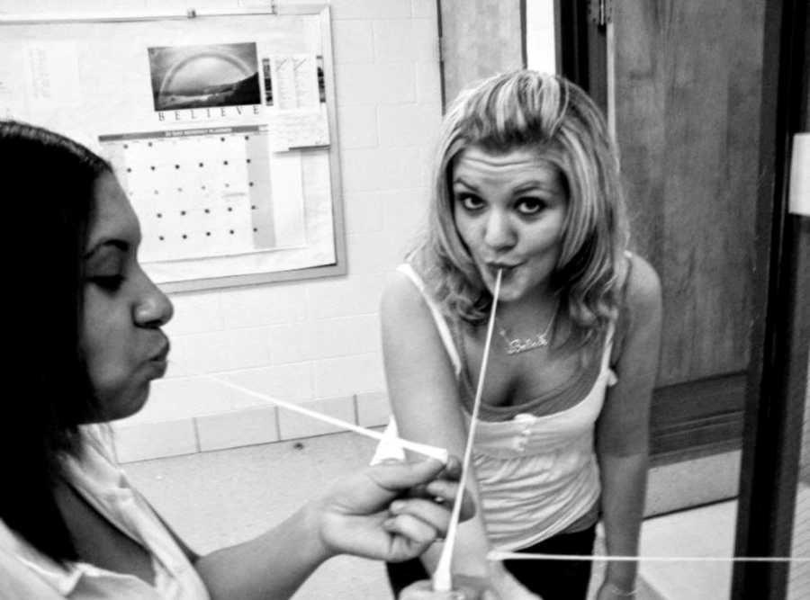 Girl in high school takes a silly photo with her friends, all chewing Juicy Fruit gum