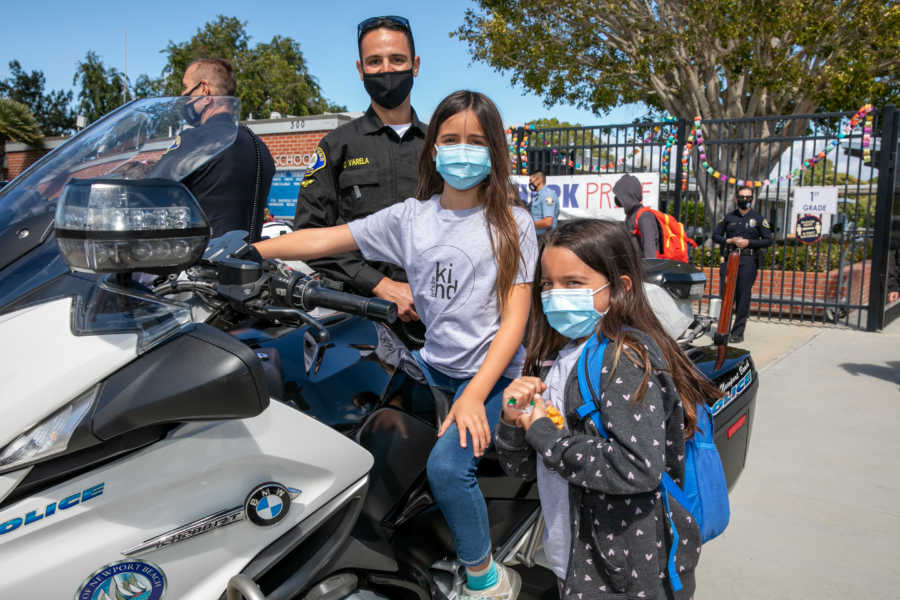 Masked girls with police officer and motorcycle