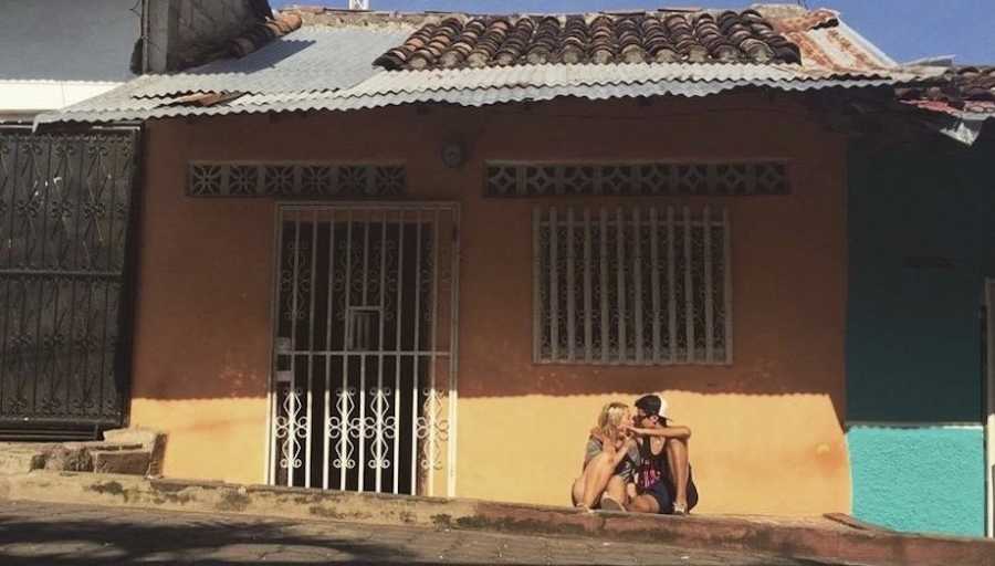 Couple posing in front of house