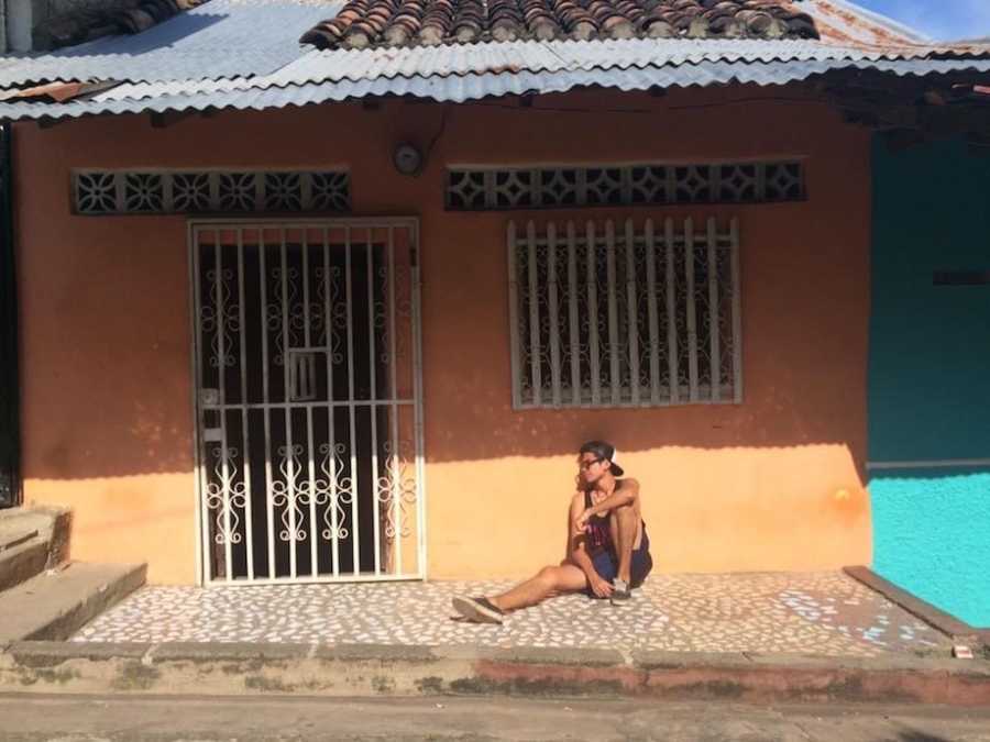 Man posing in front of house