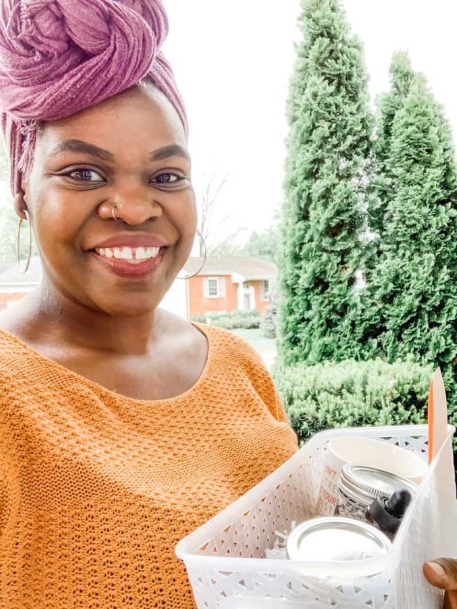 Postpartum doula takes selfie on the way to a client's house with a box of feel-good supplies