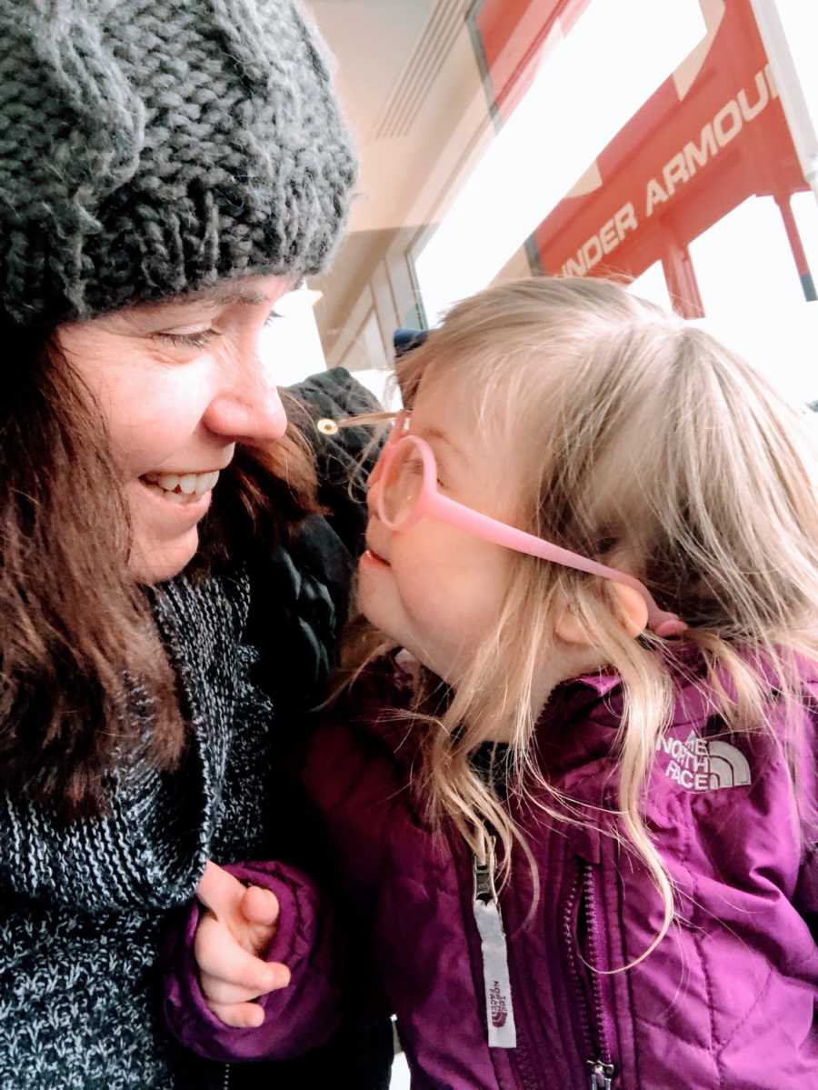 Special needs mom and daughter with Down syndrome smile at each other while in an Under Armour store