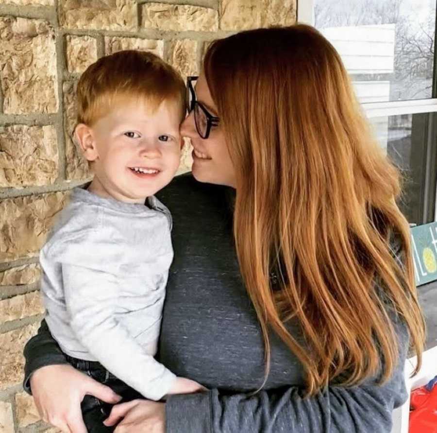 Mom with OCD holds her son with ADHD and ODD as they both smile