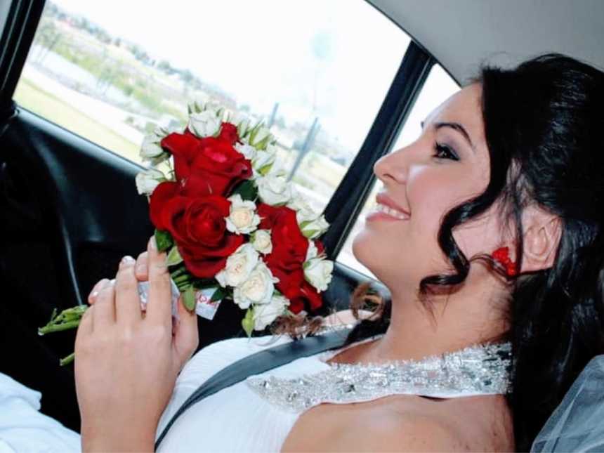 Beautiful young woman smiles on her wedding day with a red and white bouquet