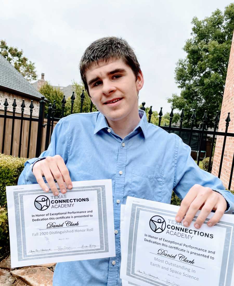 Boy with autism and apraxia hold up two academic awards he has received from Texas Connection Academy