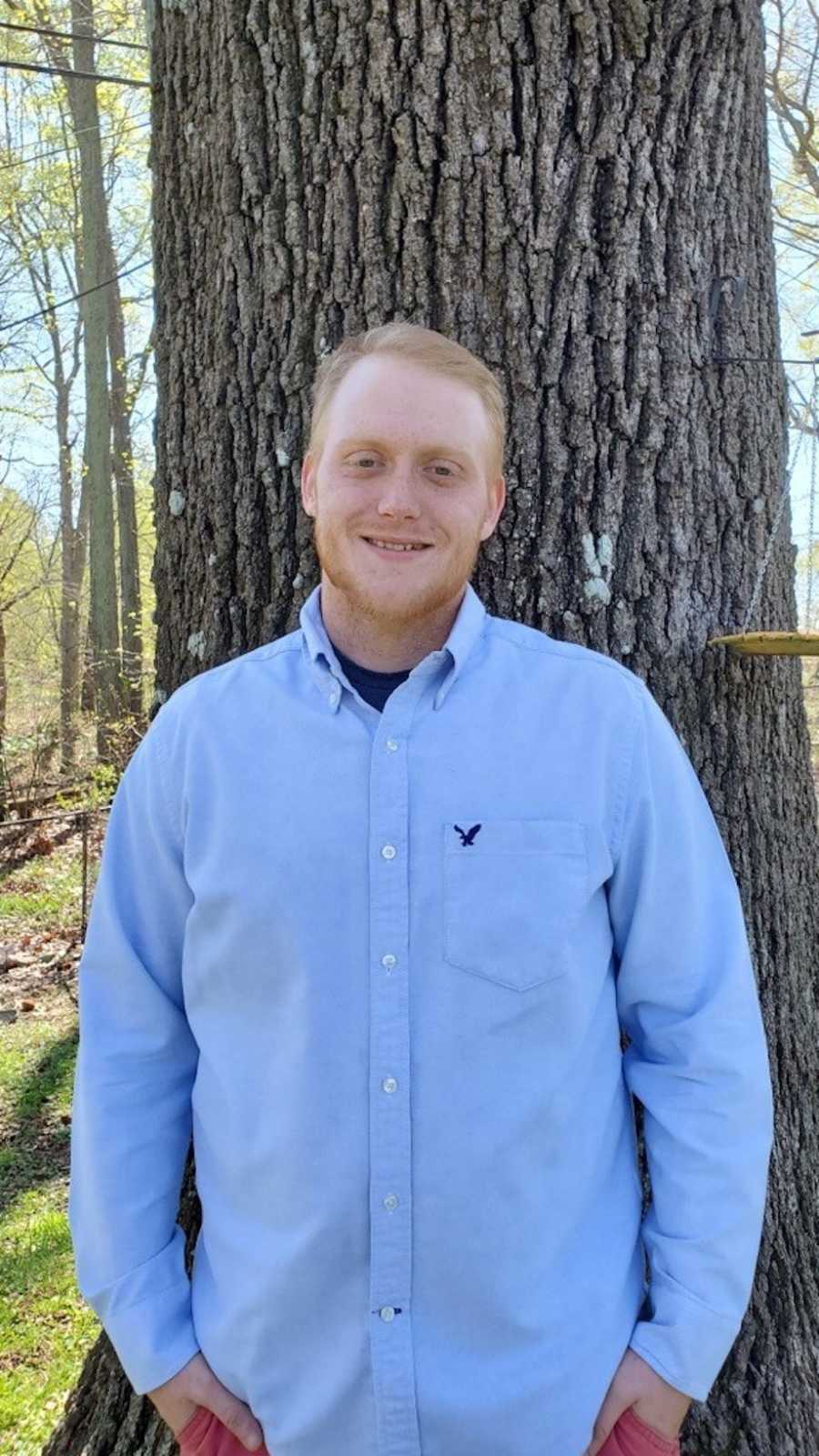 Man posing against tree