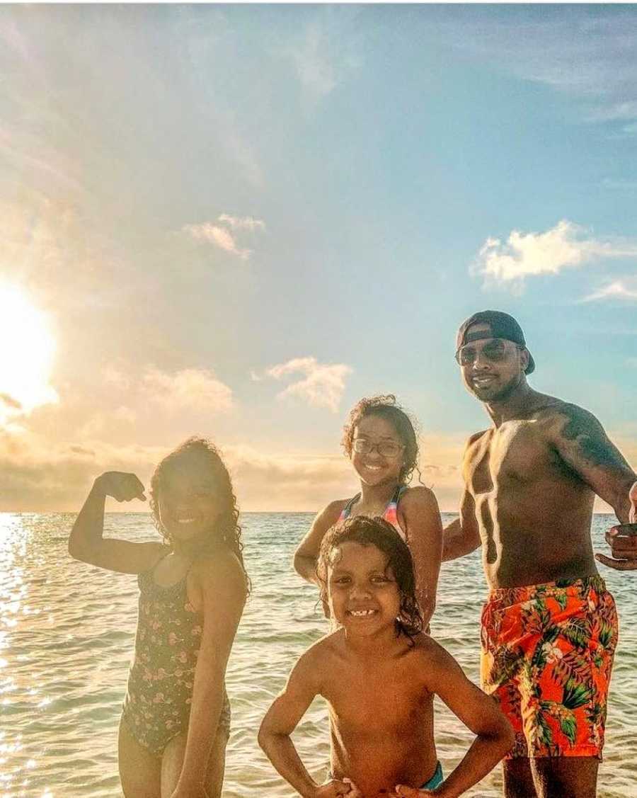 Single dad takes silly beach photo with his three children during the sunset