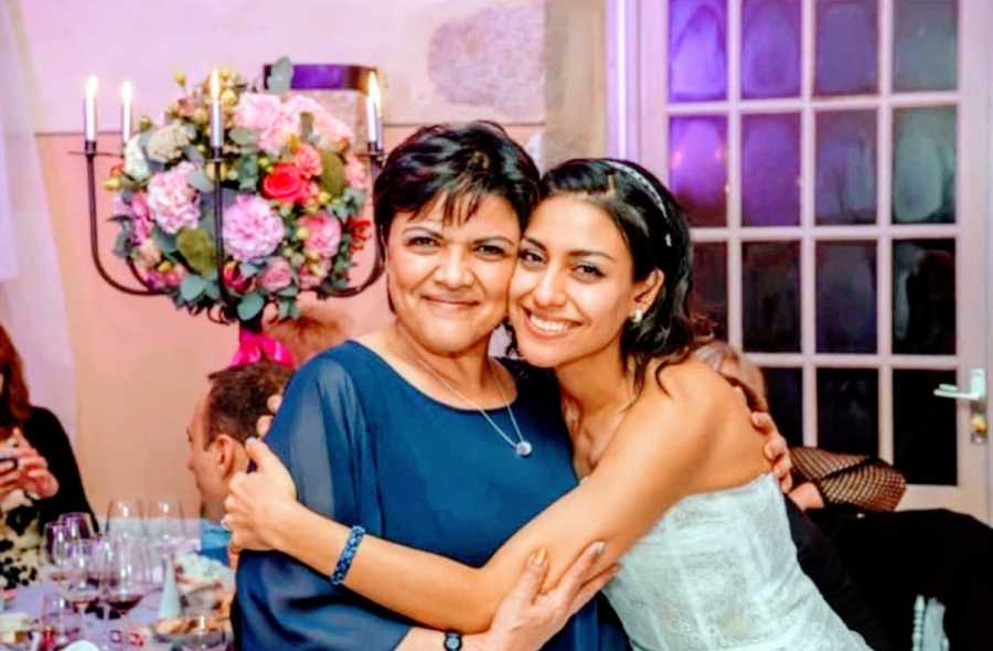 Bride takes a smiling photo with her mom during her wedding