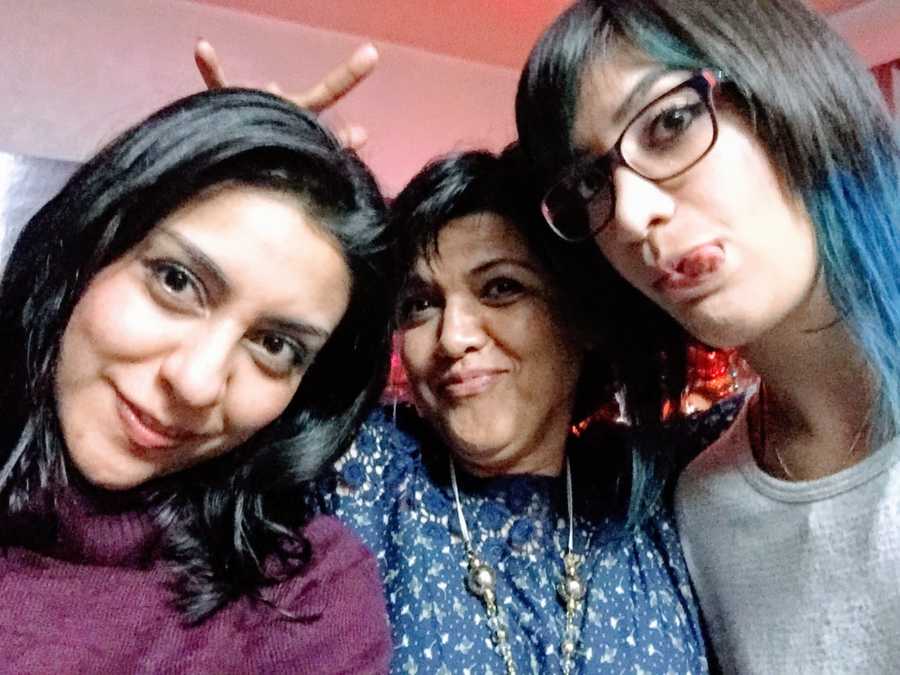 Pregnant woman takes a silly selfie with her mom and younger sister