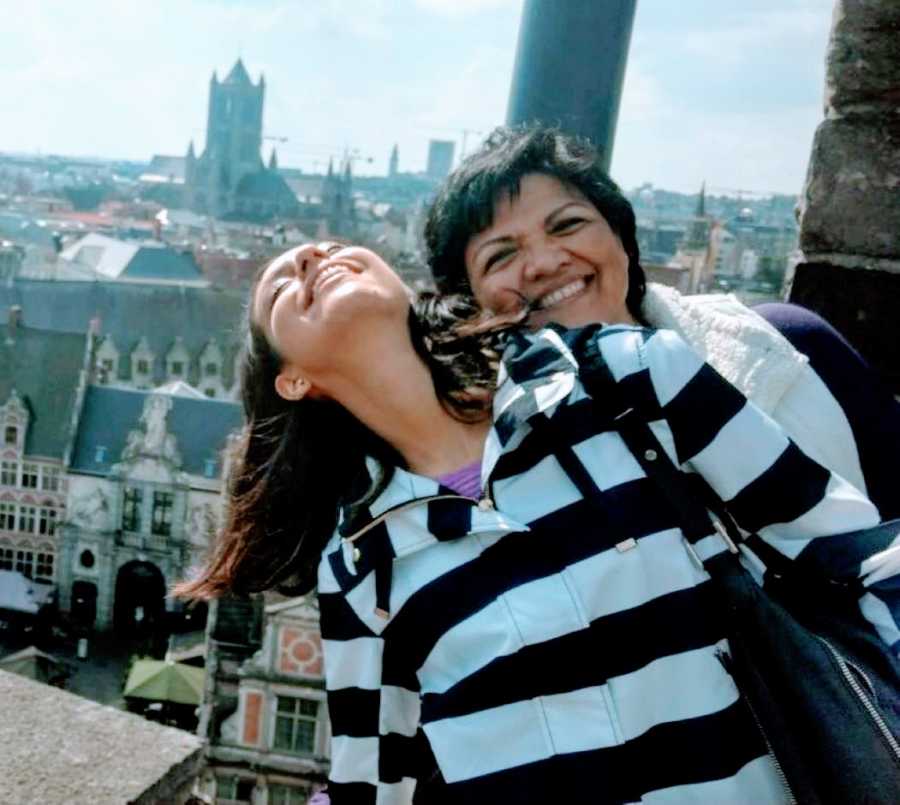 Woman laughs and smiles with her mom while sightseeing during their vacation