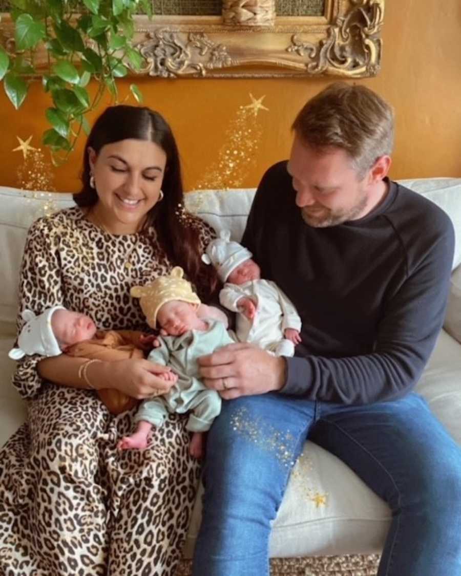 Parents holding rainbow triplets