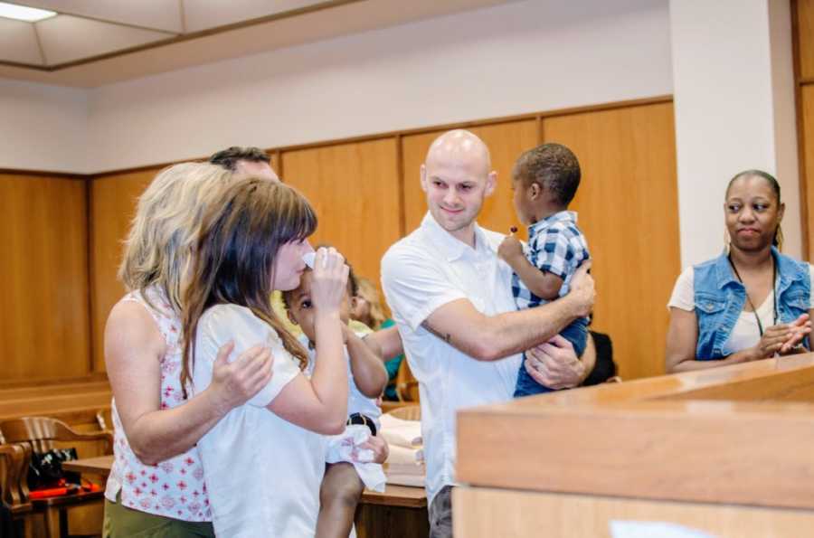 Woman starts crying in a court room during the official adoption of her children