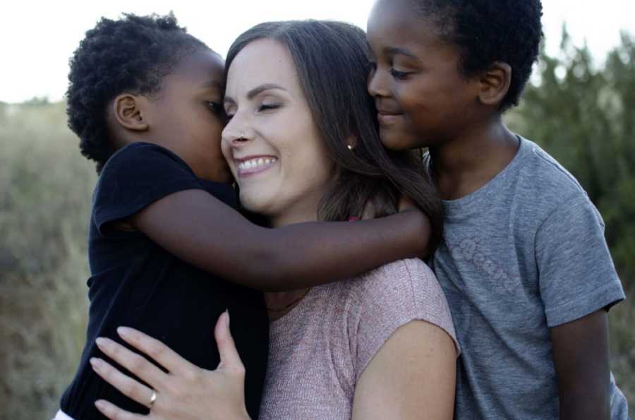 Mom hugs her two adopted children during a photoshoot