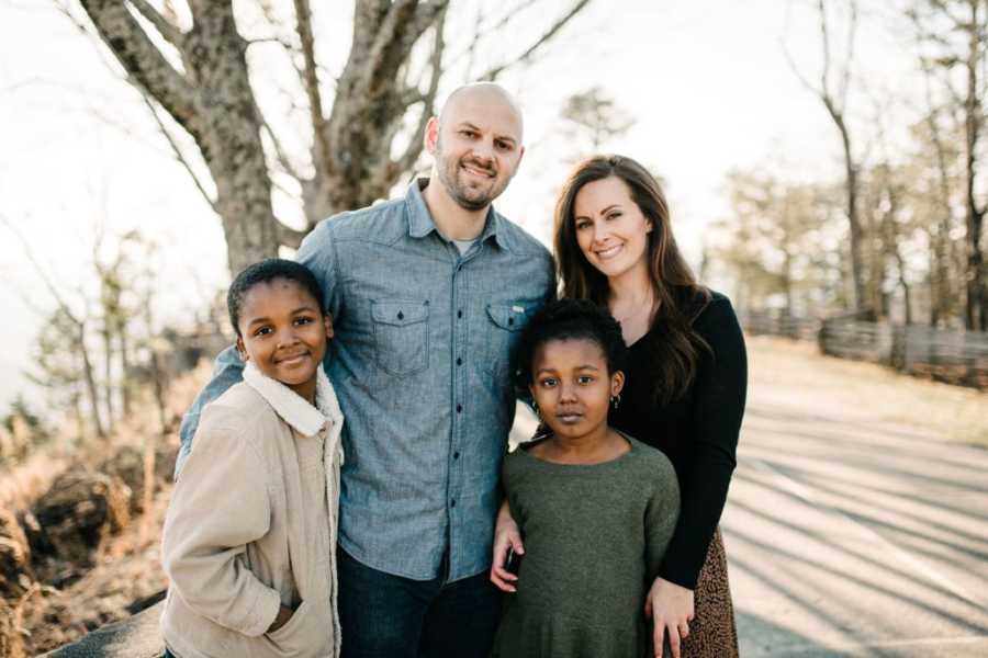Interracial family of four take a group shot during a fall photoshoot