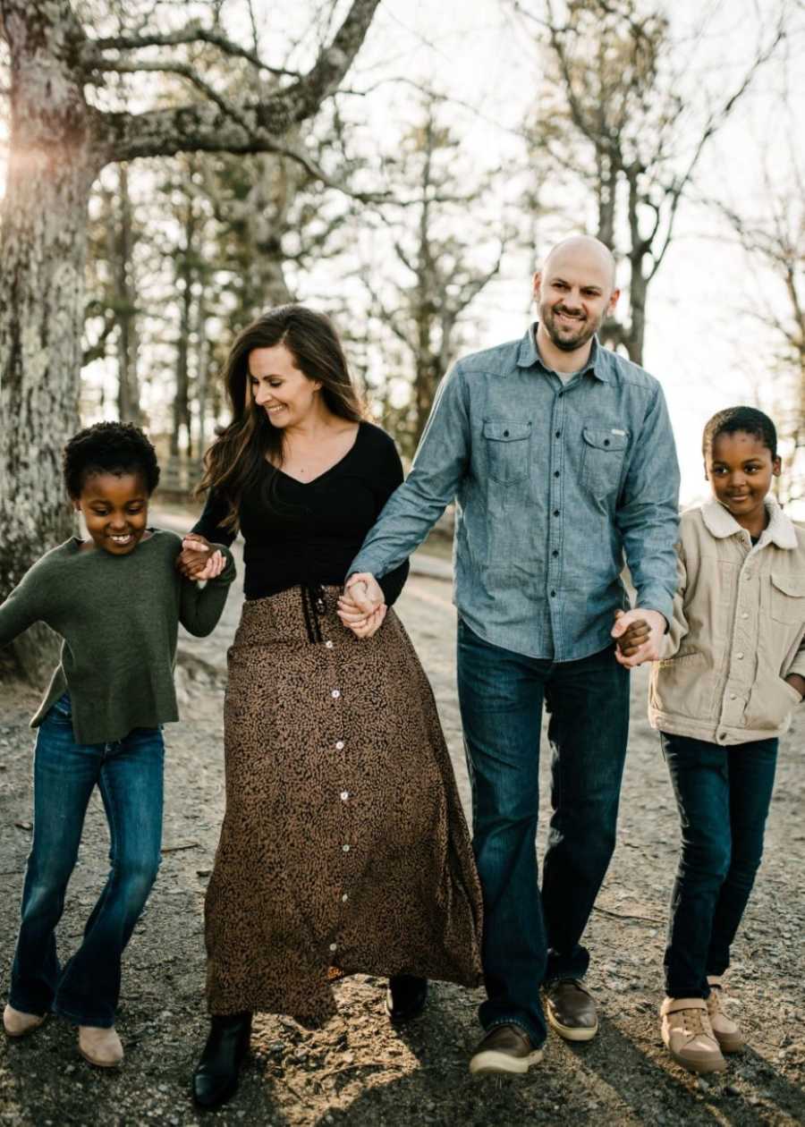 Interracial family of four take a candid photo during a fall-themed photoshoot