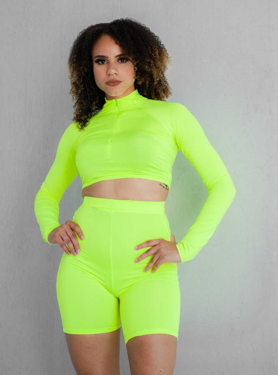 woman in neon green outfit, standing confidently