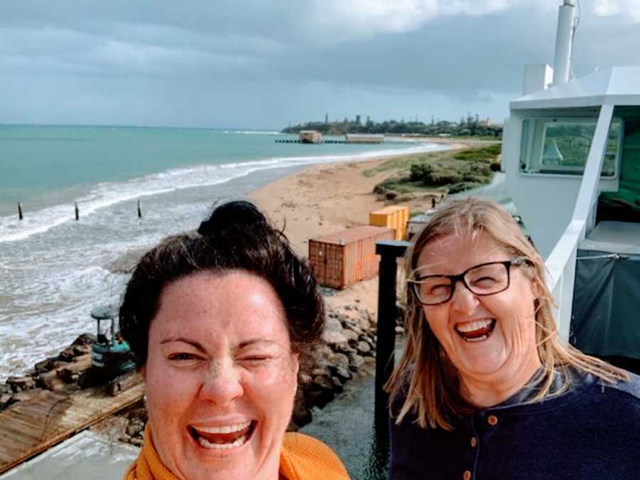 Lesbian couple take a silly selfie together while sight-seeing at the beach