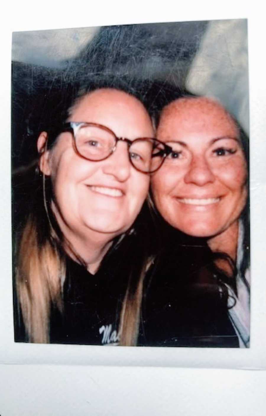 Lesbian couple take a polaroid photo together while on a date