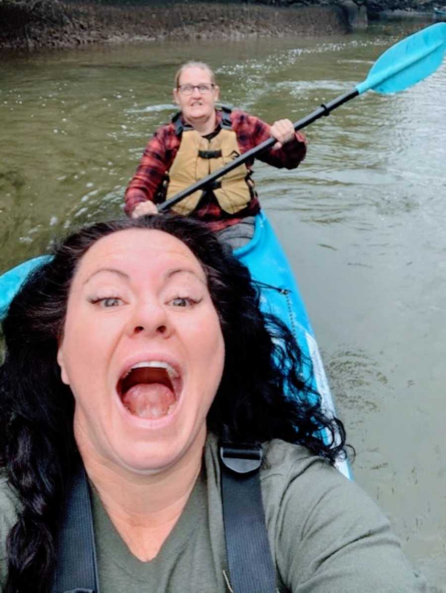 Couple take a silly selfie while out kayaking together on a river