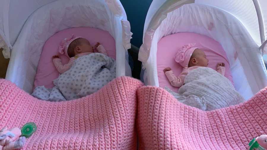 twin newborns in matching pink baskets