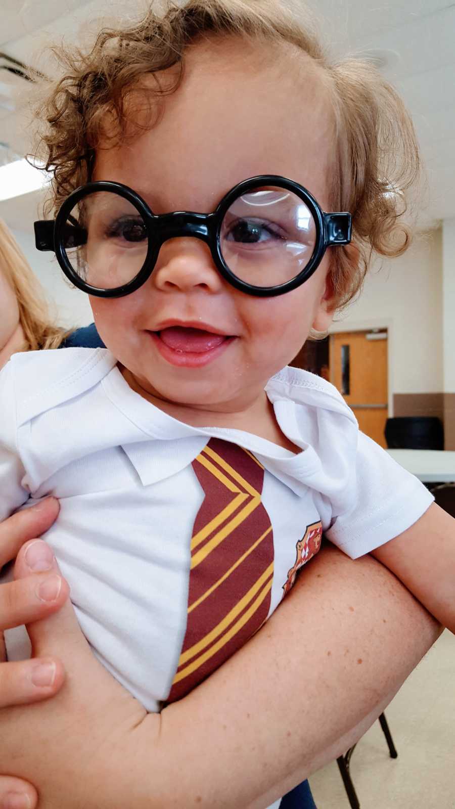 Little boy born during Harry Potter weekend smiles in Harry Potter onesie and glasses