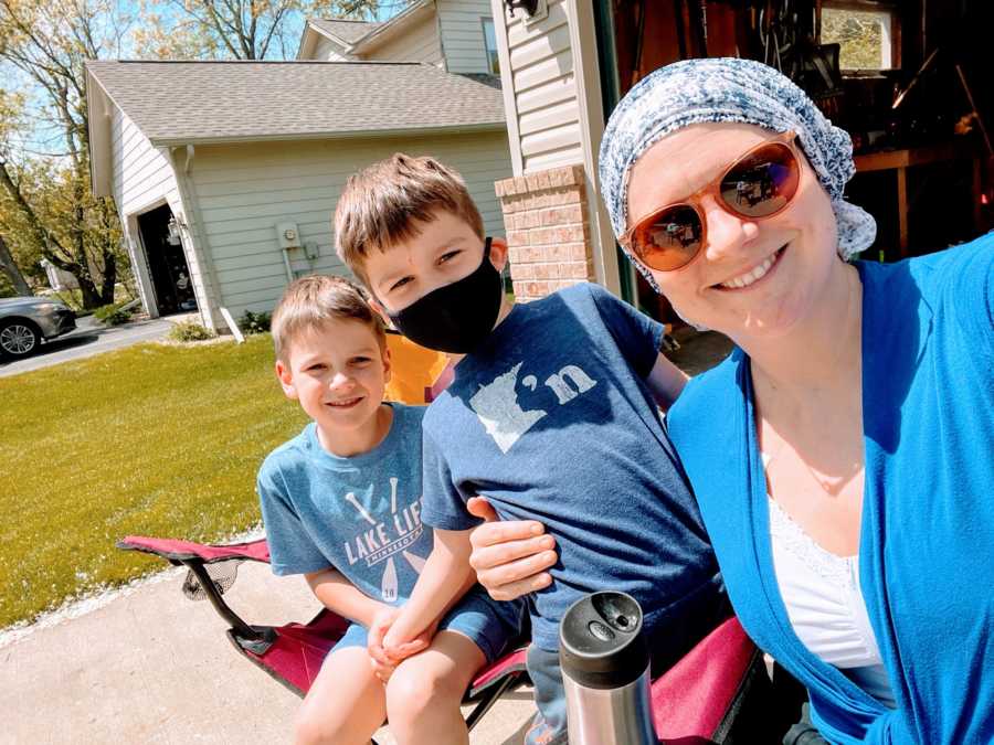 Boy mom takes a selfie with her two sons while they all enjoy some sun in their driveway