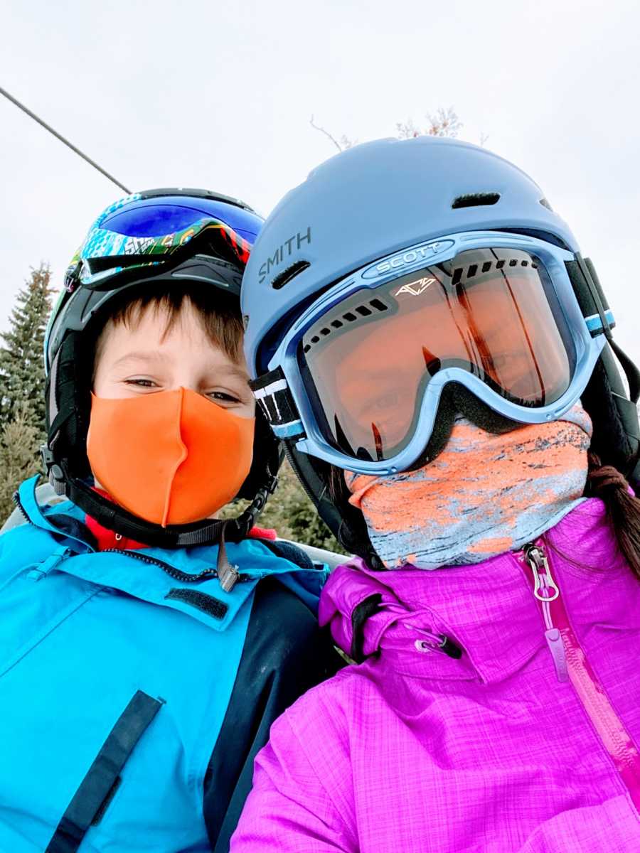 Mom takes selfie with her son, both in winter gear ready to go skiing