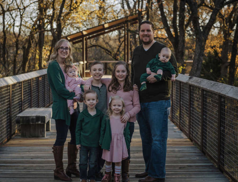 family of 8 outside on a bridge