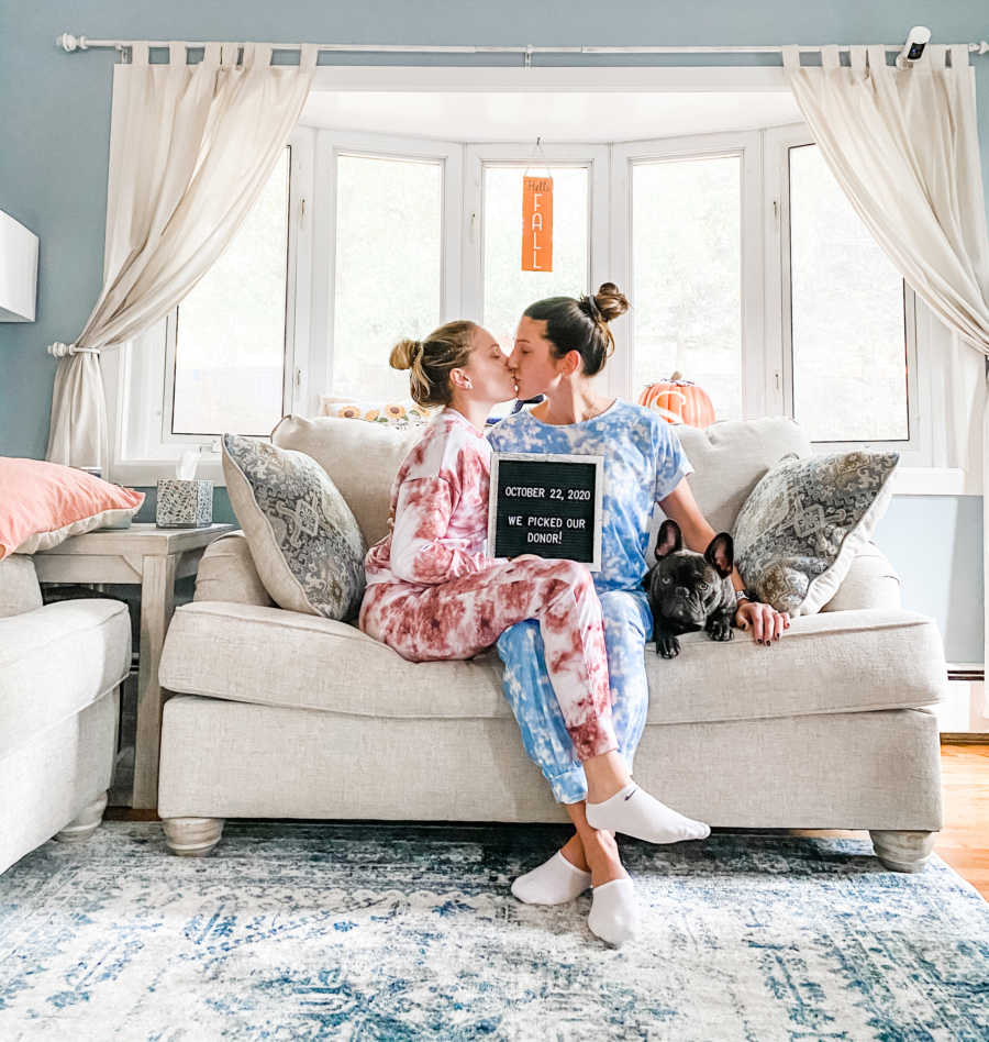 women holding a sign "we picked our donor" on couch