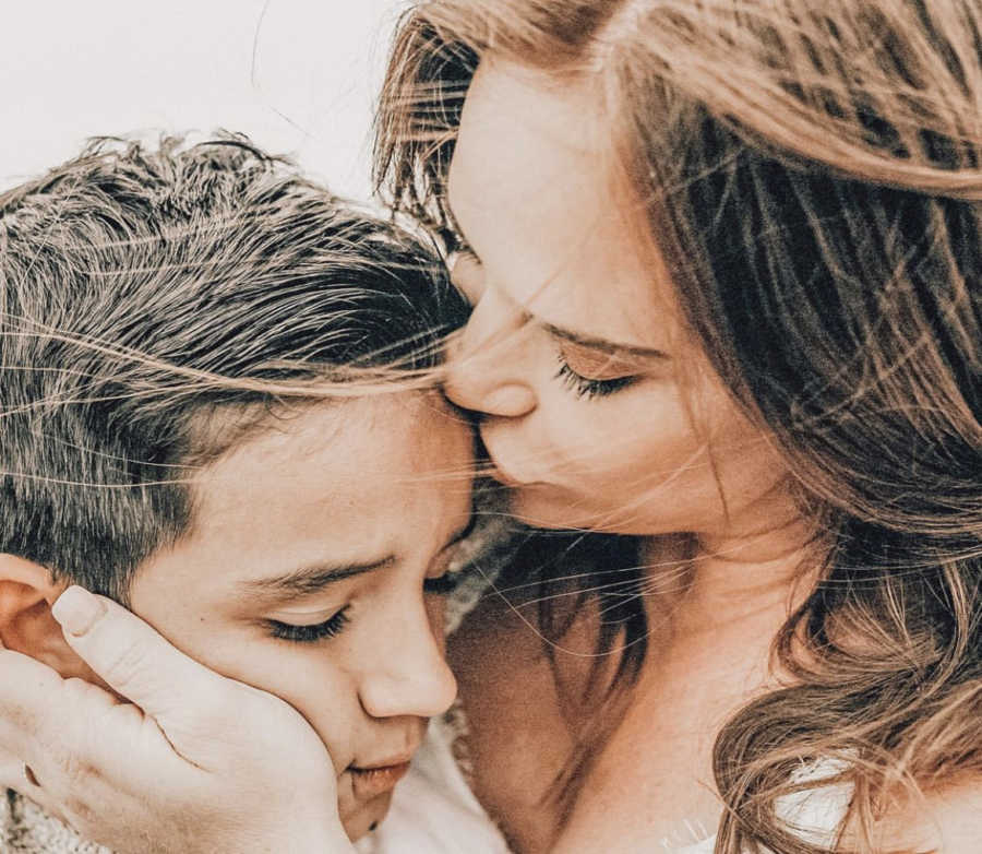 A mom kissing her son