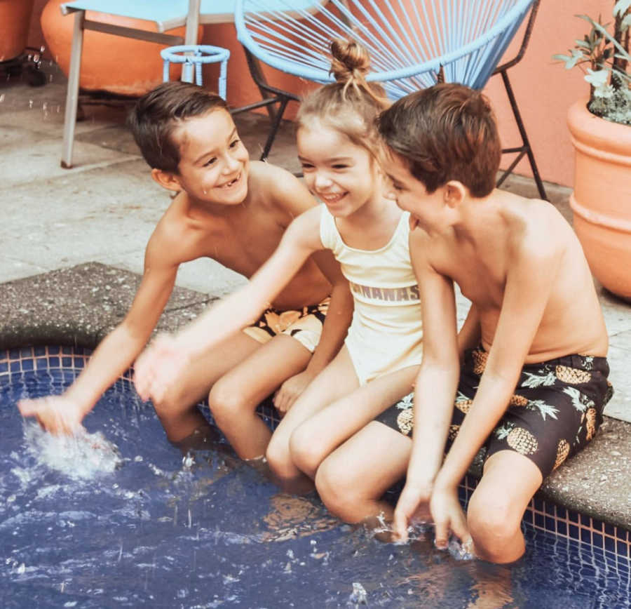 three kids playing in the pool