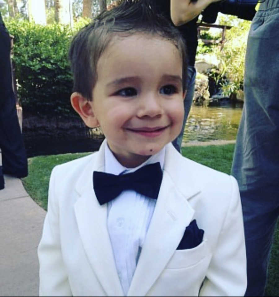 a little boy in a white suit