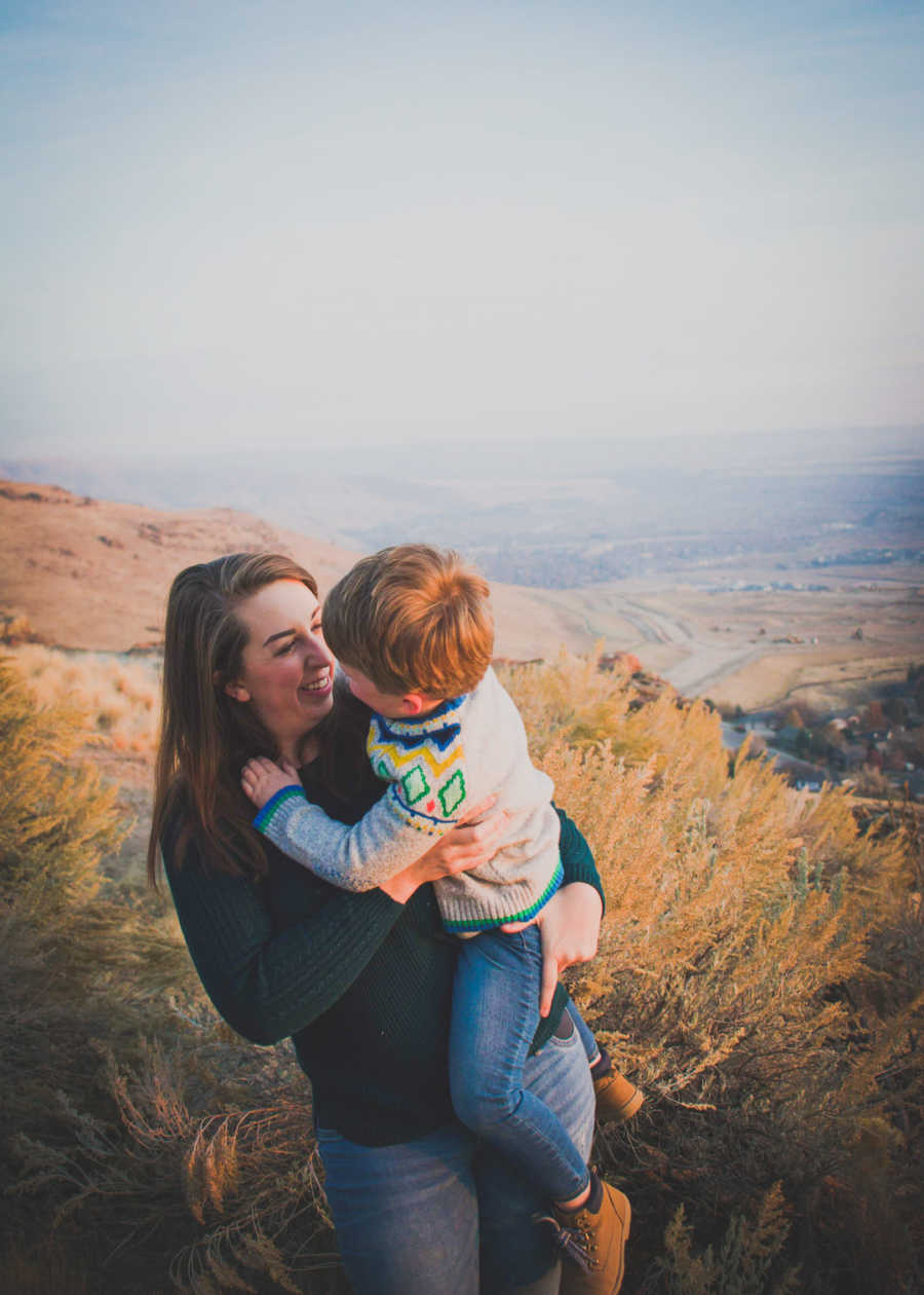 Mother holding son out in nature