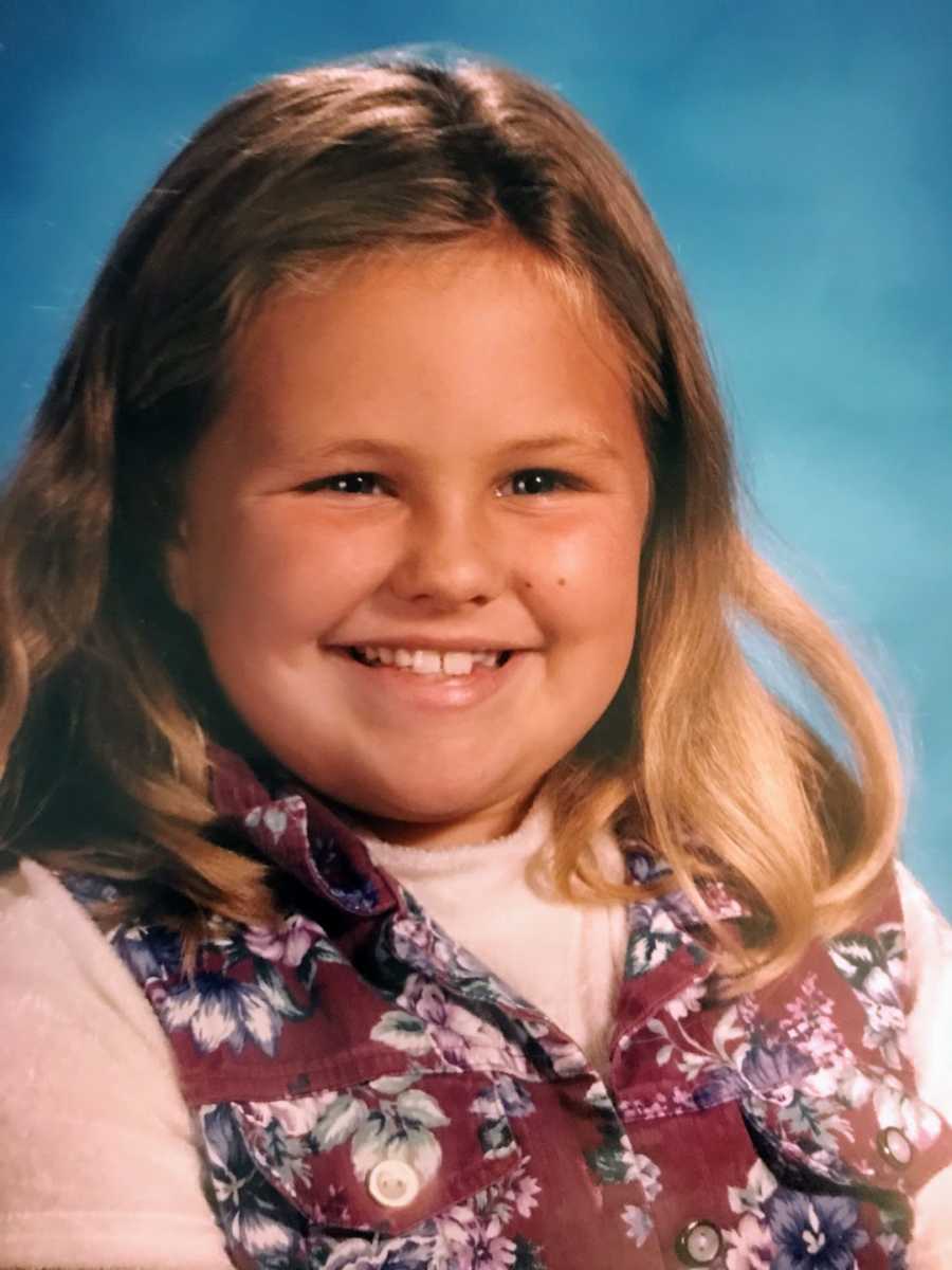 Young girl wearing floral shirt smiling for school photo