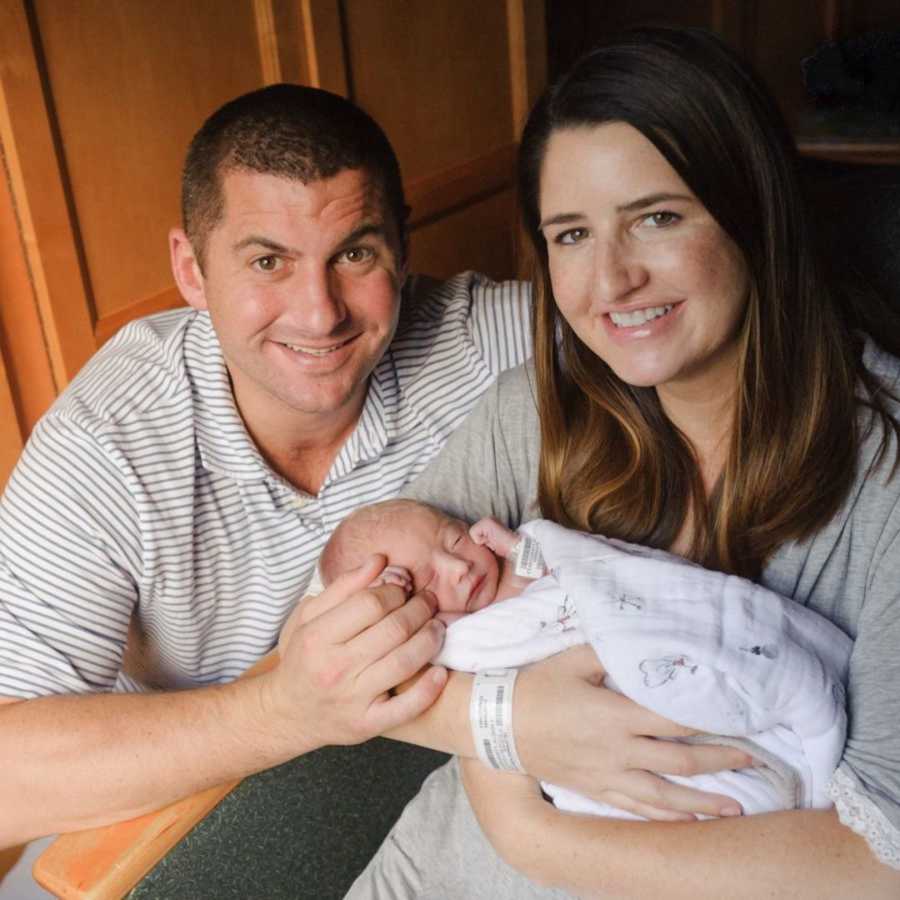 New parents holding newborn son in hospital