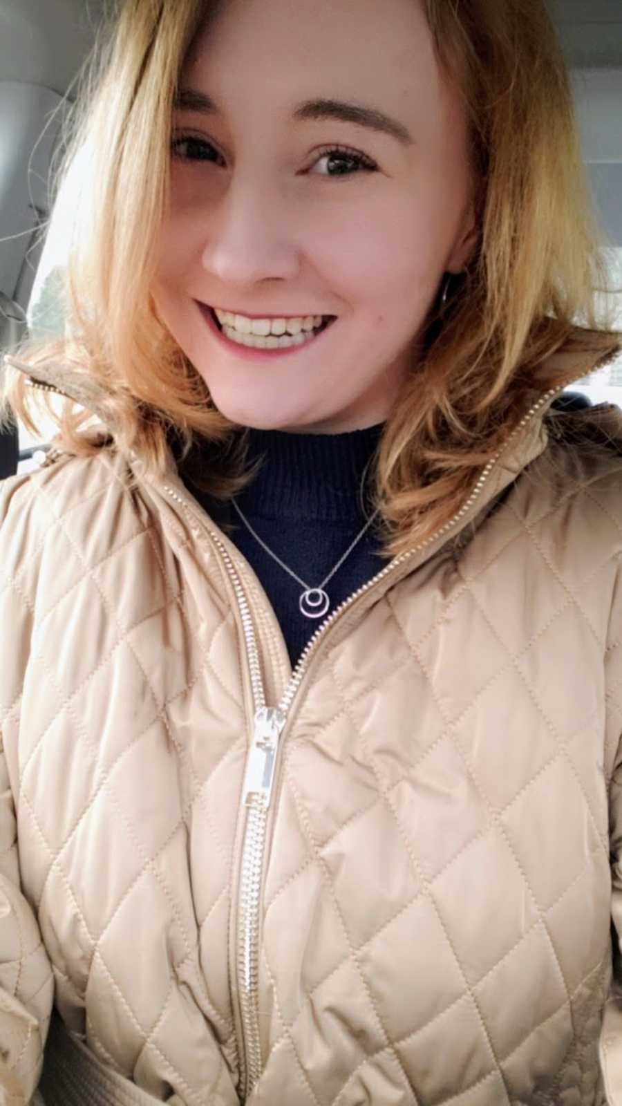 Woman wearing coat taking smiling selfie