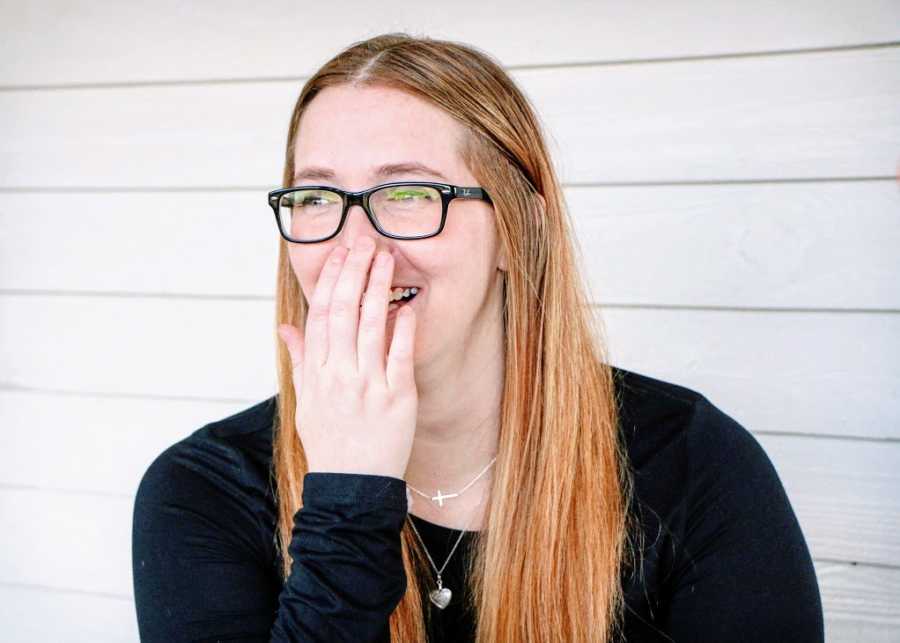 A disabled woman laughing and smiling despite her pain