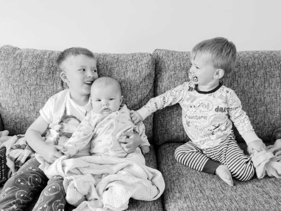 Three brothers sitting on couch black and white photo