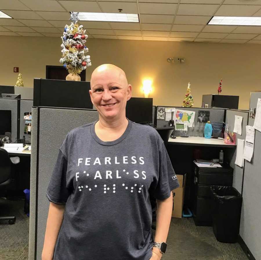 Bald woman standing in office smiling