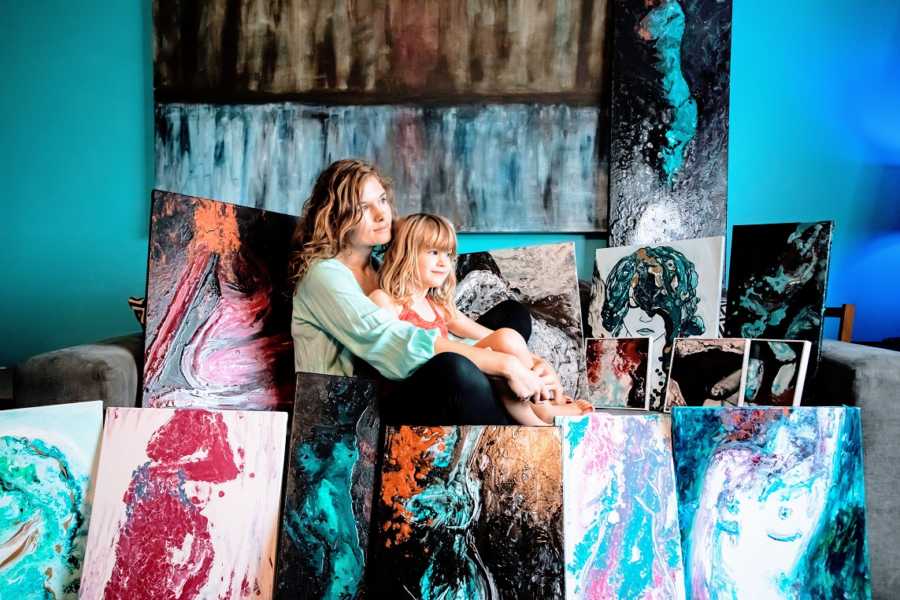 A neurodivergent woman and her daughter surrounded by artwork