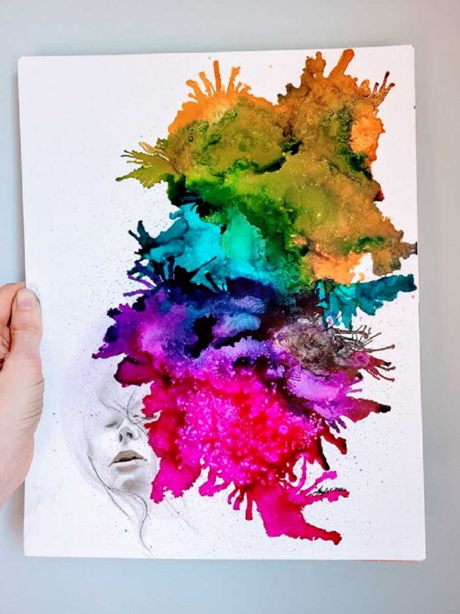 A piece of art with rainbow colors coming from a face